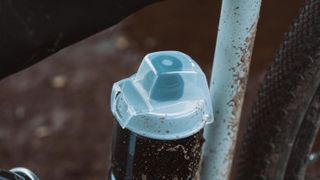 A close up of a water bottle with a cap in a bike frame